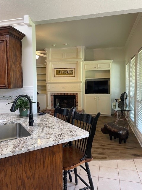 kitchen with a kitchen breakfast bar, a brick fireplace, plenty of natural light, and sink