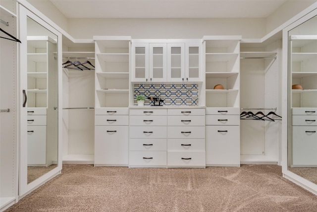 walk in closet featuring light carpet