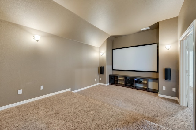 carpeted home theater with vaulted ceiling