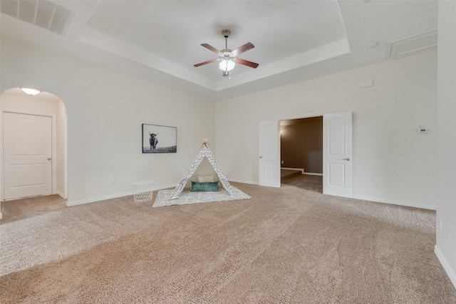 rec room featuring carpet floors, a raised ceiling, and ceiling fan