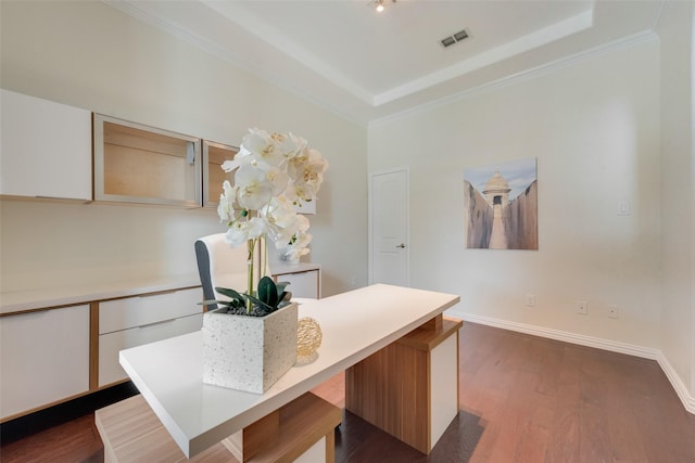 interior space featuring crown molding, dark hardwood / wood-style flooring, and a raised ceiling