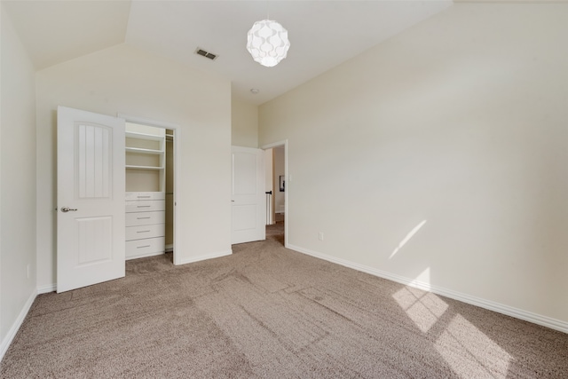 unfurnished bedroom featuring a closet, carpet, and lofted ceiling