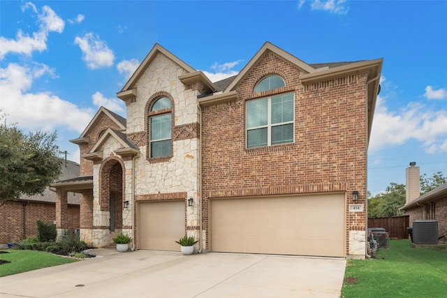 view of front of property featuring a garage and central AC