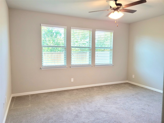 carpeted spare room featuring ceiling fan