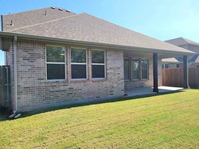 rear view of house featuring a patio and a lawn