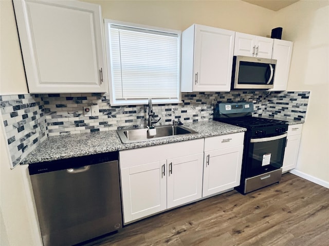 kitchen featuring decorative backsplash, white cabinetry, appliances with stainless steel finishes, and sink