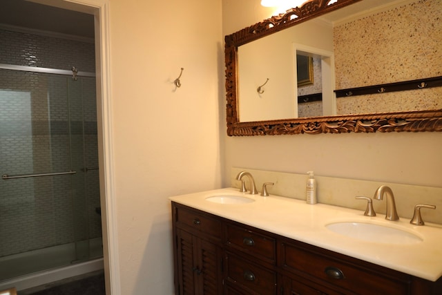 bathroom with a shower with door, vanity, and ornamental molding