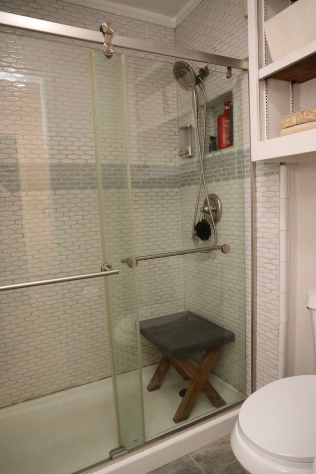 bathroom featuring tile patterned floors, toilet, an enclosed shower, and ornamental molding