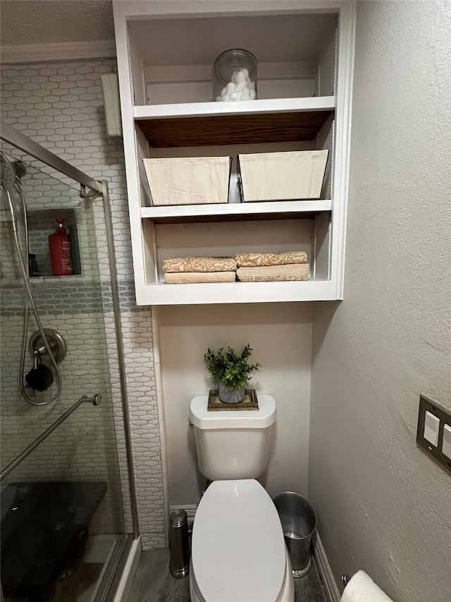 bathroom featuring wood-type flooring, toilet, and a shower with shower door