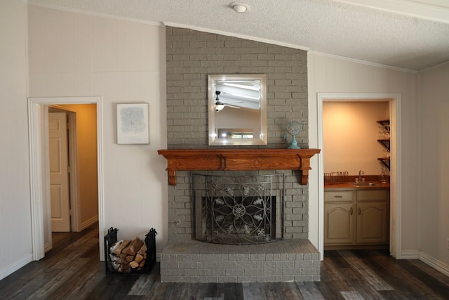 living room with a textured ceiling, dark hardwood / wood-style floors, lofted ceiling, and sink