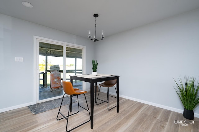 dining space featuring a notable chandelier and light hardwood / wood-style floors