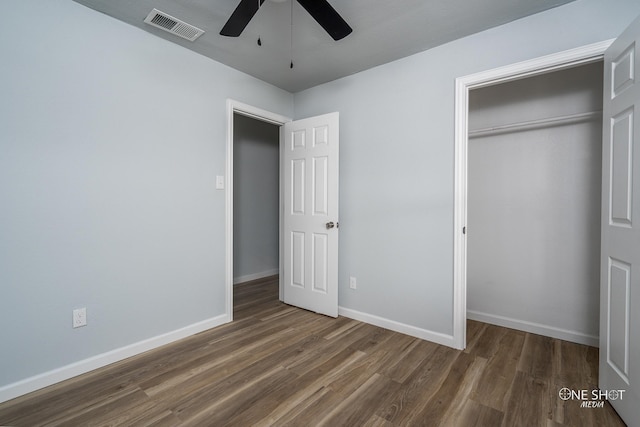 unfurnished bedroom with dark hardwood / wood-style flooring, a closet, and ceiling fan