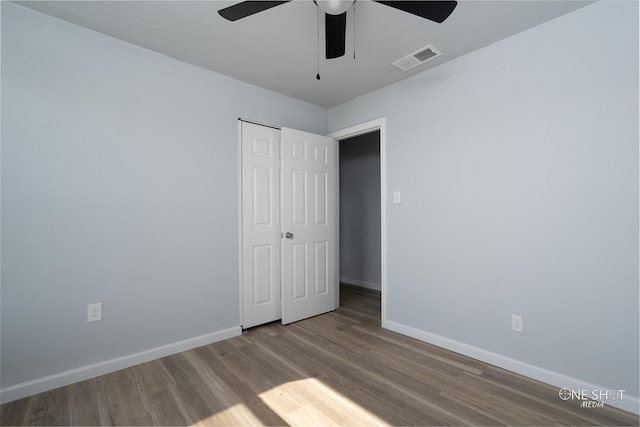 unfurnished bedroom featuring hardwood / wood-style floors, a closet, and ceiling fan