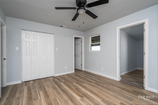 unfurnished bedroom with wood-type flooring, a closet, and ceiling fan