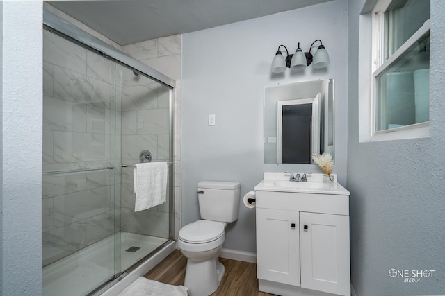 bathroom featuring vanity, wood-type flooring, an enclosed shower, and toilet