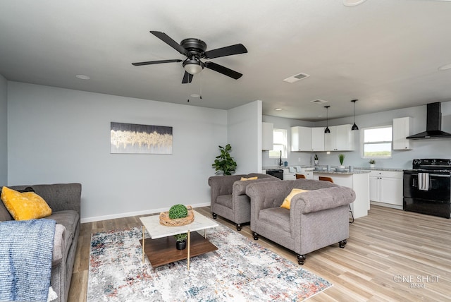 living room with ceiling fan and light hardwood / wood-style floors