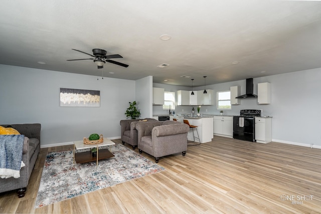 living room with ceiling fan and light hardwood / wood-style flooring