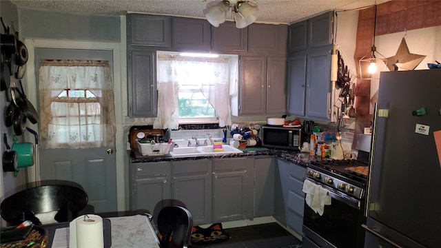 kitchen with gray cabinets, black appliances, a textured ceiling, and sink