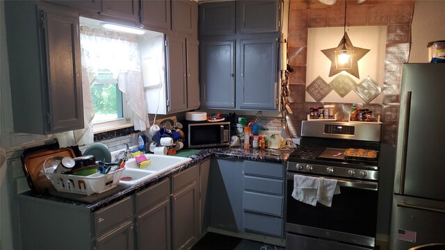 kitchen featuring gray cabinets, stainless steel appliances, hanging light fixtures, and sink