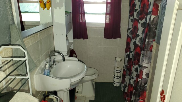 bathroom featuring tile walls, a shower with curtain, and toilet