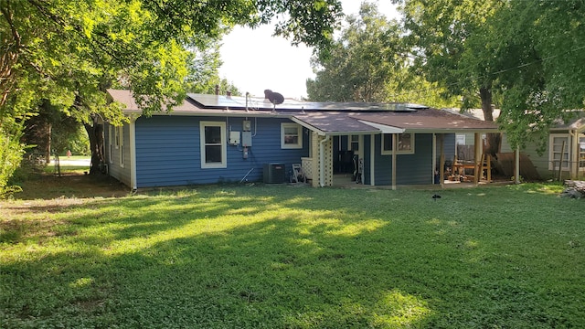 back of house featuring central AC unit and a yard