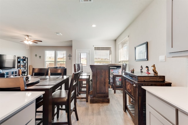 dining space with ceiling fan and light hardwood / wood-style flooring