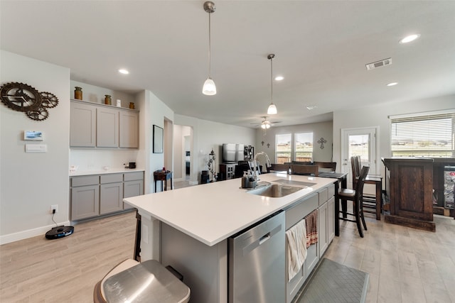 kitchen featuring light hardwood / wood-style flooring, dishwasher, and a center island with sink