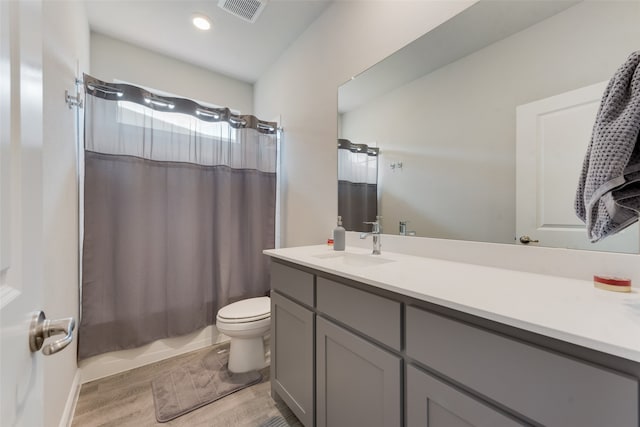 full bathroom with vanity, hardwood / wood-style floors, toilet, and shower / tub combo