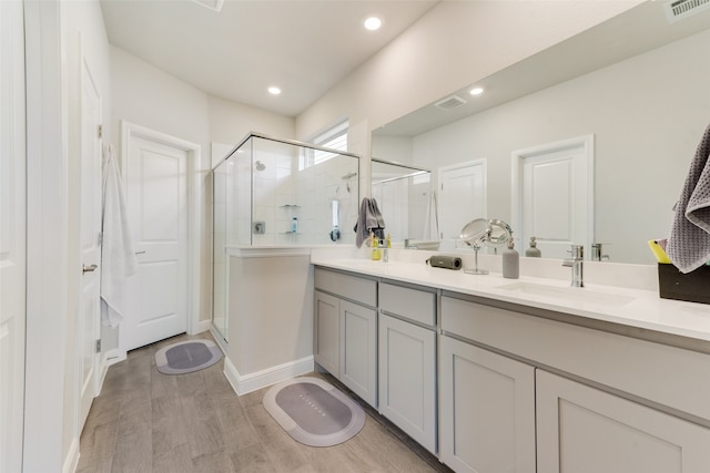 bathroom featuring walk in shower, vanity, and hardwood / wood-style flooring