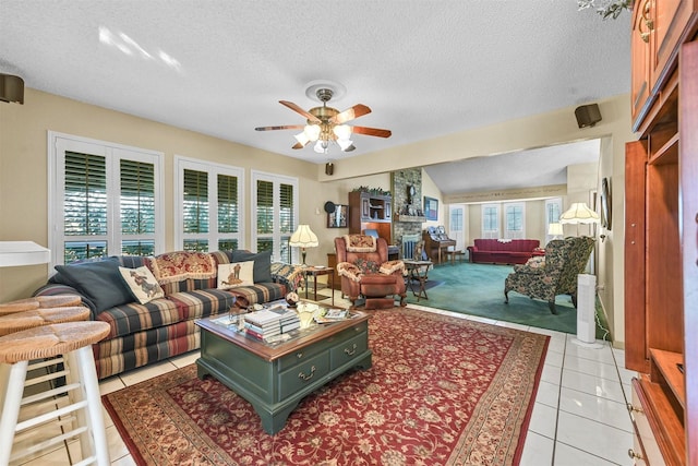 tiled living room with lofted ceiling, ceiling fan, and a textured ceiling