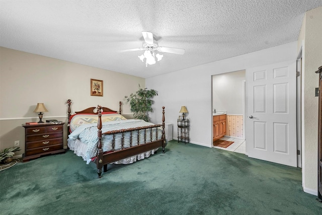 bedroom with ceiling fan, light colored carpet, a textured ceiling, and ensuite bath