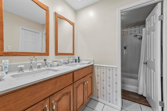 bathroom with tile patterned floors, shower / tub combo with curtain, vanity, and a textured ceiling