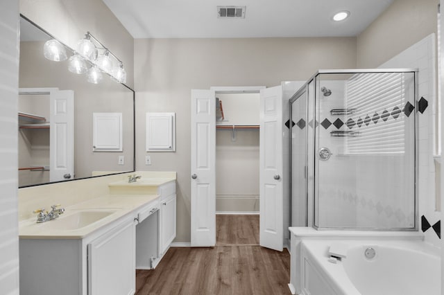 bathroom with shower with separate bathtub, vanity, and wood-type flooring