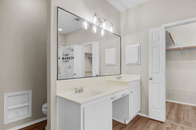 bathroom with vanity, a shower, toilet, and hardwood / wood-style flooring