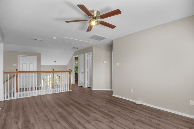 empty room with ceiling fan, vaulted ceiling, and dark wood-type flooring