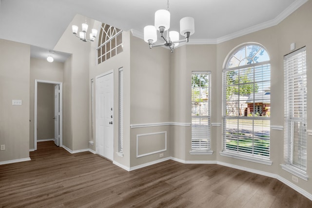 unfurnished dining area featuring crown molding, dark hardwood / wood-style floors, and a notable chandelier