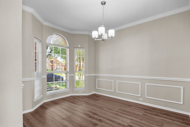 unfurnished room featuring ornamental molding, an inviting chandelier, and dark wood-type flooring