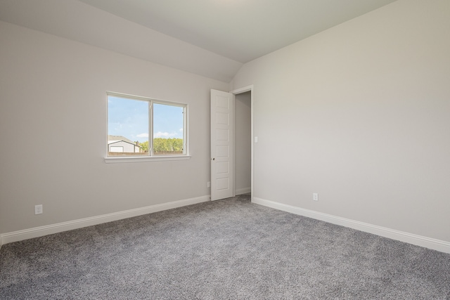 spare room with lofted ceiling and carpet flooring