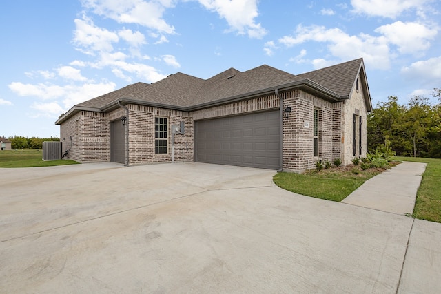 view of front of home with a garage and central AC