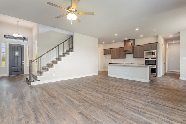 kitchen with ceiling fan, premium range hood, stainless steel microwave, and dark hardwood / wood-style flooring