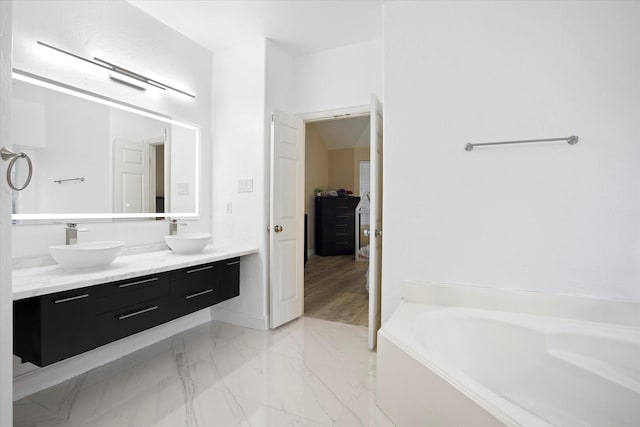 bathroom featuring vanity and a bath