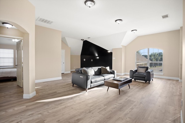 living room featuring light wood-type flooring and vaulted ceiling