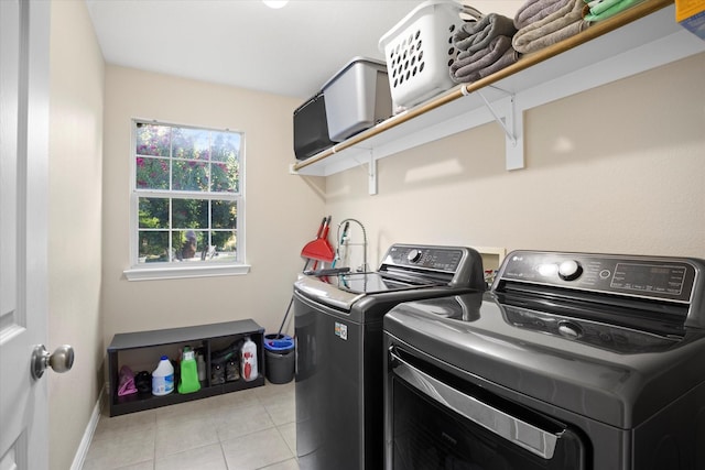 laundry area with washing machine and dryer and light tile patterned flooring