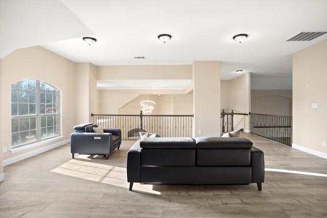 living room featuring an inviting chandelier and light wood-type flooring