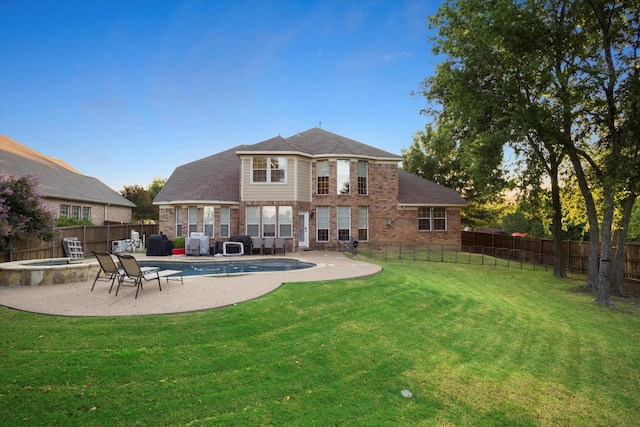 back of house with a yard, a fenced in pool, and a patio