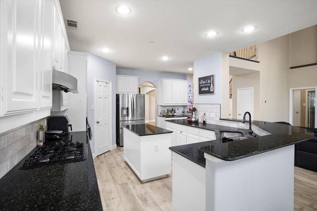 kitchen with sink, black gas cooktop, white cabinets, stainless steel fridge with ice dispenser, and a center island