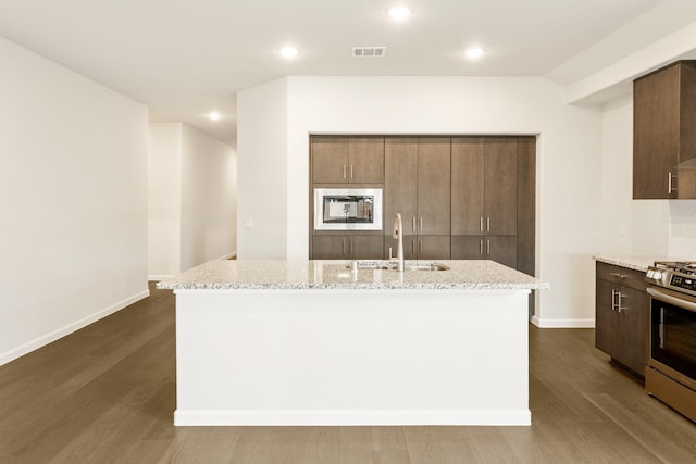 kitchen featuring a kitchen island with sink, sink, dark hardwood / wood-style floors, and stainless steel range oven