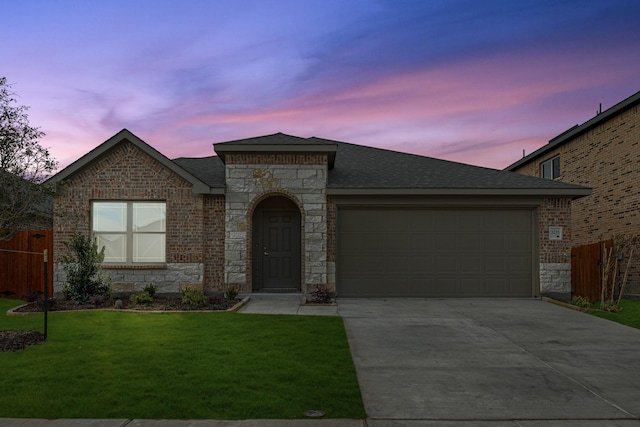 view of front of property with a garage and a lawn