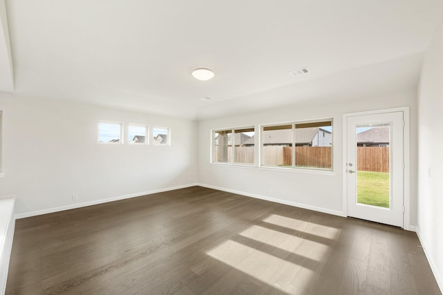 unfurnished room with plenty of natural light and dark wood-type flooring