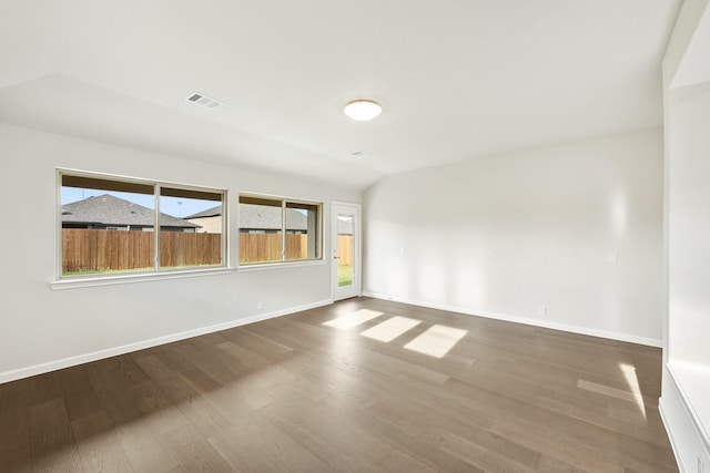 unfurnished room featuring hardwood / wood-style floors and vaulted ceiling